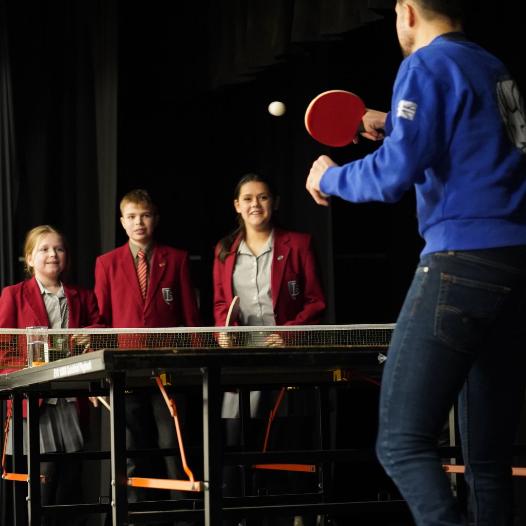 Paralympian Will Bayley playing table tennis with students at Lingfield College